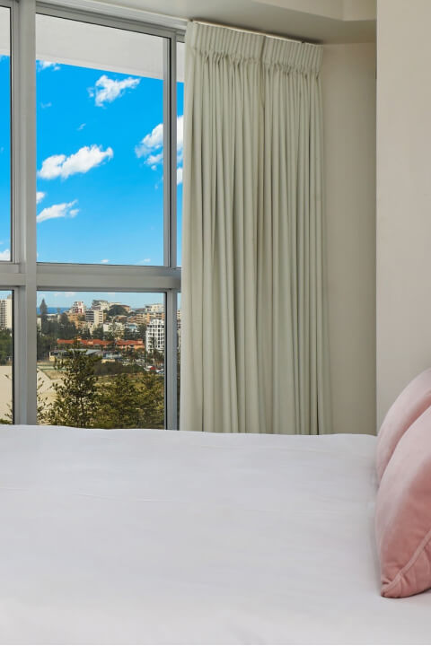 Bedroom at ULTIQA Points North with ocean and beach views through large windows.