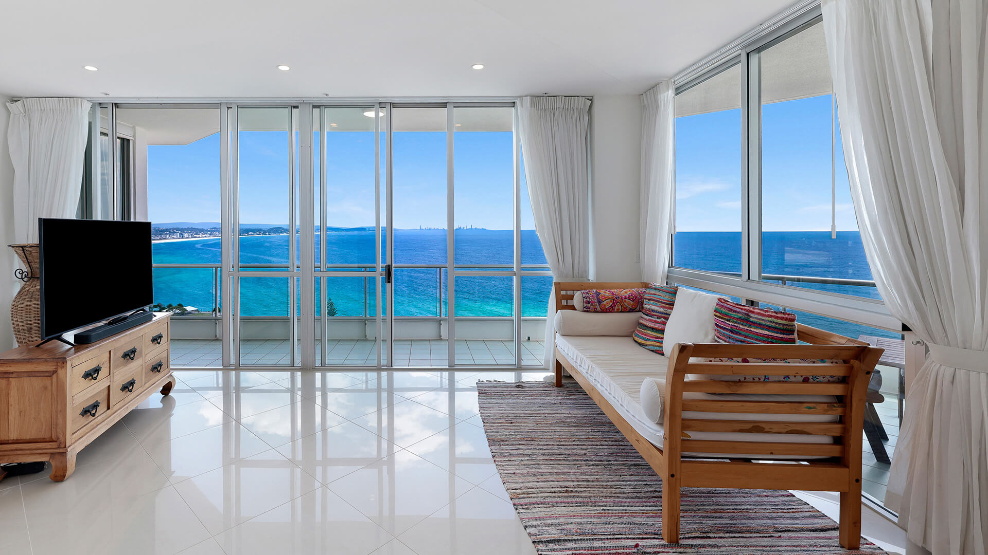 Lounge area of the 4 Bedroom Oceanfront Penthouse at ULTIQA Points North with balcony and ocean views.
