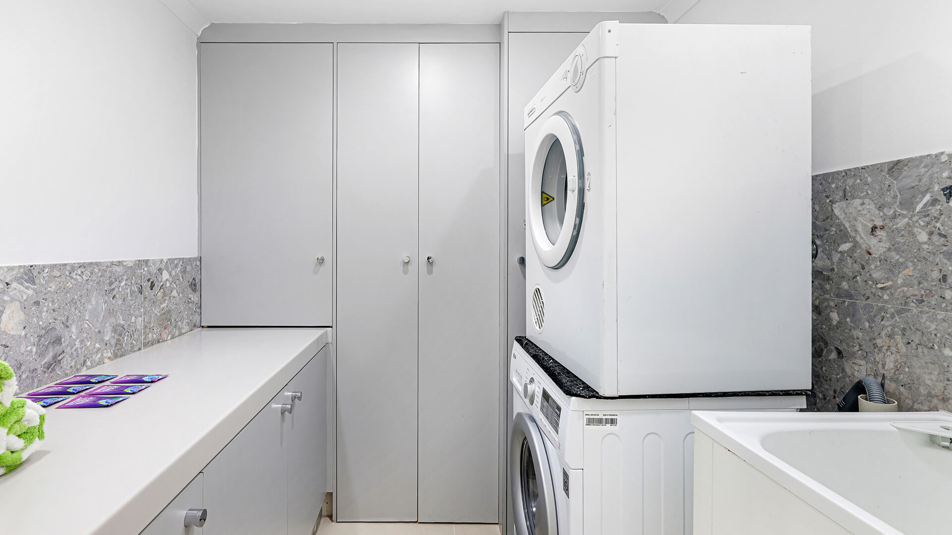 Laundry room in the 4 Bedroom Oceanfront Penthouse at ULTIQA Points North with washer, dryer, and storage cabinets.