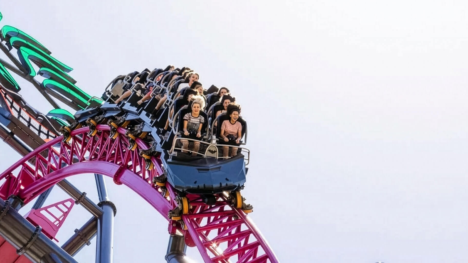 People enjoying a thrilling roller coaster ride at a Gold Coast theme park.