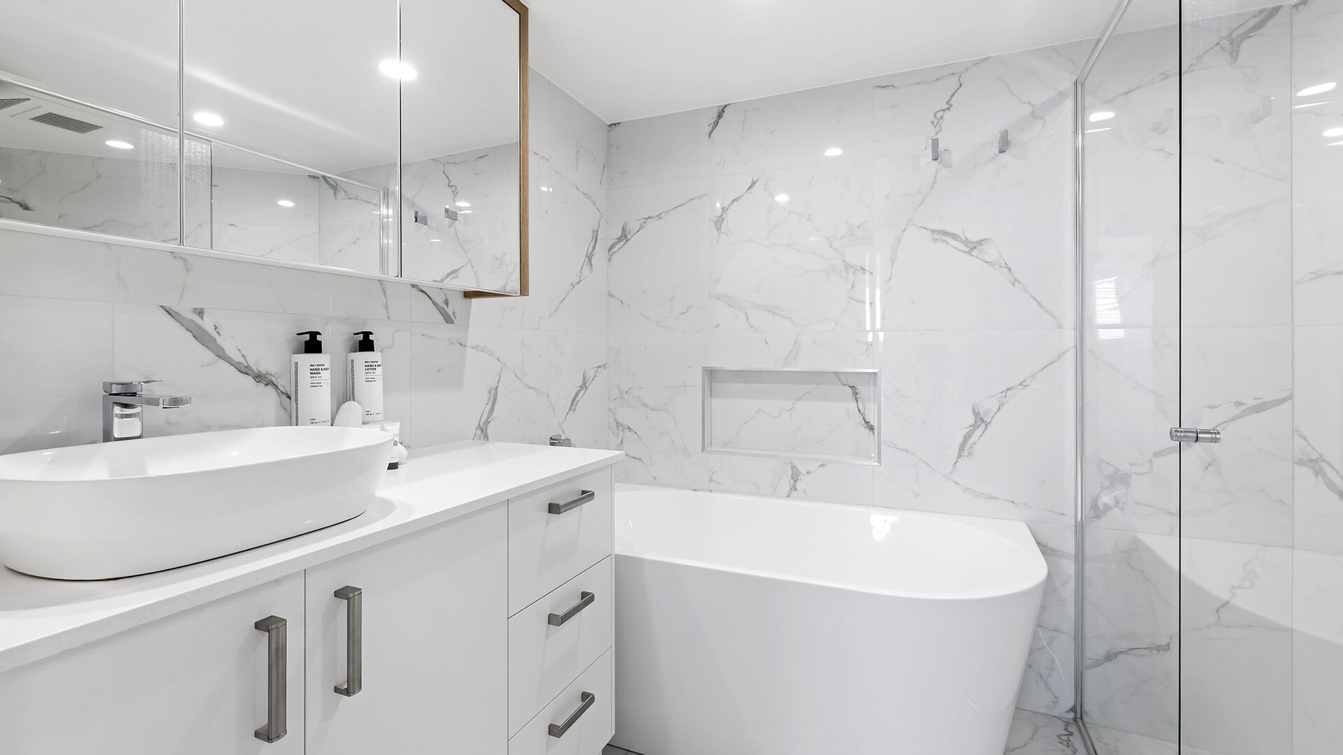 Modern bathroom in the Deluxe 3 Bedroom Ocean View Apartment, featuring a freestanding bath, walk-in shower and marble-style finishes.