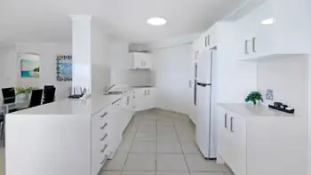 Dining area of the 2 Bedroom Superior Ocean View Apartment with a glass table, black chairs, and open layout to the lounge and balcony.